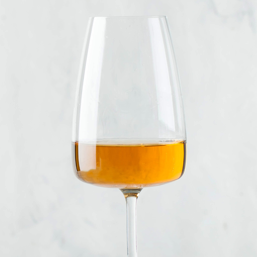 Glass of orange wine aka amber wine aka skin contact white wine